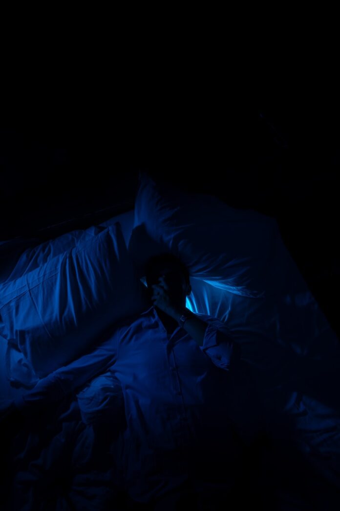 Photo by Mohamed Jamil Latrach A person laying in a bed in a dark room