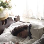 “슬기로운 수면 습관, 한국인의 건강 지키는 첫걸음” woman sleeping on bed beside book