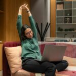 근육 건강, 생활 속에서 실천하는 새로운 트렌드 a woman sitting on a couch using a laptop