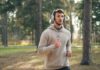 지루함을 이기는 귀의 마법: 플레이리스트와 팟캐스트 활용법 Man with headphones running in a forest