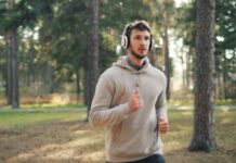 지루함을 이기는 귀의 마법: 플레이리스트와 팟캐스트 활용법 Man with headphones running in a forest