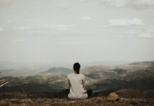 집에서 실천하는 ‘마음챙김 산책’… 심신이 건강해지는 새로운 트렌드 woman sitting on cliff overlooking mountains during daytime
