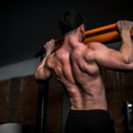 근육이 건강의 키워드로, 근력 운동 열풍이 바꾼 라이프스타일 topless man in black shorts holding orange bar