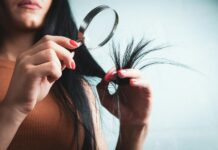 집에서 시작하는 건강한 모발 관리, 최신 트렌드와 실천 팁 Woman examining split ends of hair with magnifying glass