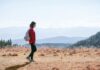 걷기 열풍, 일상 속 건강 지키는 작은 변화가 만든다 a man with a backpack walking across a dry grass covered field