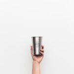 마시는 건강, ‘웰빙 워터’가 바꾼 일상…내 몸에 맞는 물 마시기 실천법 person holding gray stainless steel drinking cup