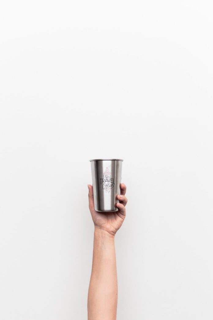Photo by Andrew Neel person holding gray stainless steel drinking cup