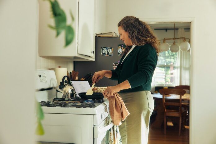 Photo by Microsoft Copilot Woman cooking on a stovetop in a kitchen
